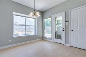 en empty room with windows and chandelier