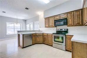 a kitchen with granite countertop cabinets stainless steel appliances a sink and a window