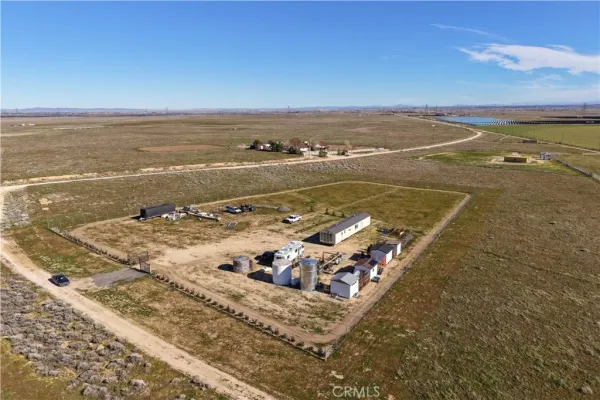 an aerial view of ocean and residential houses with outdoor space
