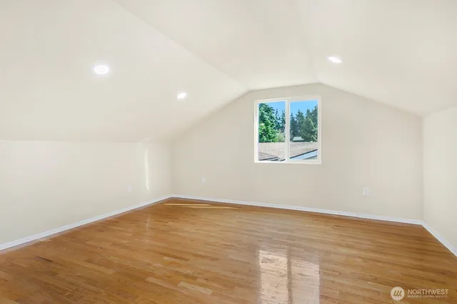 an empty room with wooden floor and window