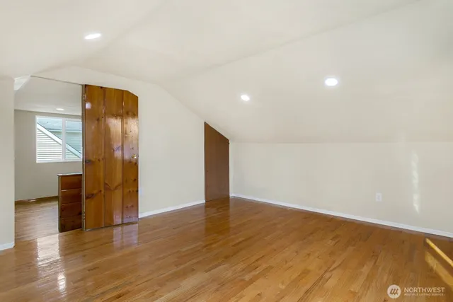 an empty room with wooden floor and entrance