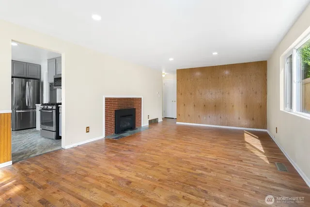 a view of empty room with wooden floor and fireplace