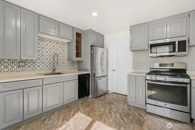 a kitchen with stainless steel appliances granite countertop a stove a refrigerator and a sink