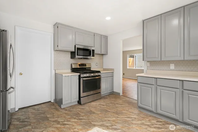 a kitchen with white cabinets and stainless steel appliances