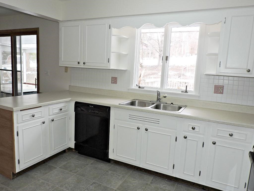 4894 Brookview Road Rockford, IL 61107 - Photo 6 of 21 a kitchen with white cabinets and a window
