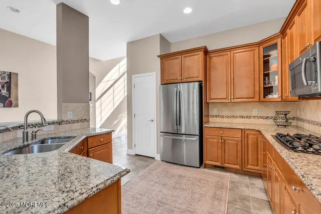 a kitchen with stainless steel appliances granite countertop a refrigerator and a stove top oven