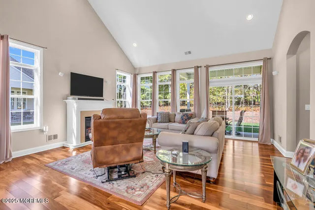 a living room with furniture a fireplace and large windows