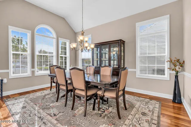 a dining room with furniture a chandelier and wooden floor