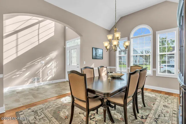 a view of a dining room with furniture wooden floor and a chandelier