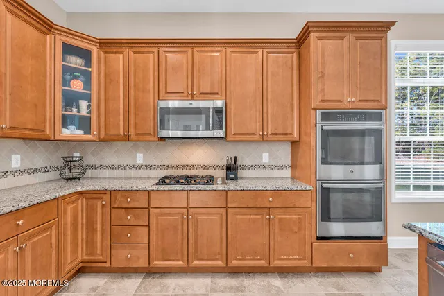 a kitchen with stainless steel appliances granite countertop a stove a sink and a microwave