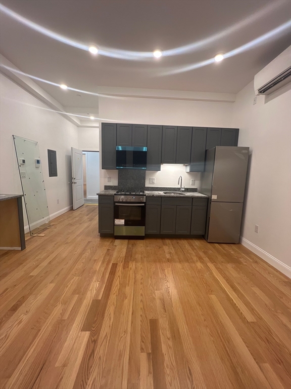 52 Washington, Unit 302 Chelsea, MA 02150 - Photo 2 of 12 a living room with furniture and a flat screen tv