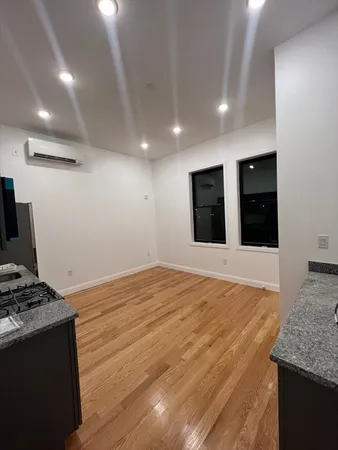 a view of an empty room with wooden floor