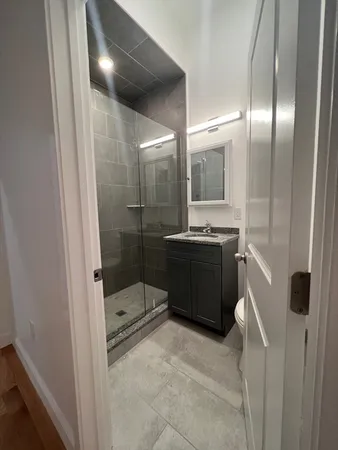 a bathroom with double vanity and a glass door shower