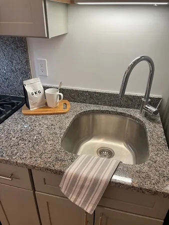 a bathroom with a granite countertop sink toilet a mirror and shower