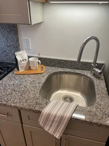 a bathroom with a granite countertop sink toilet a mirror and shower