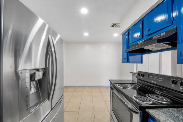 a kitchen with stainless steel appliances granite countertop a stove a refrigerator and a sink