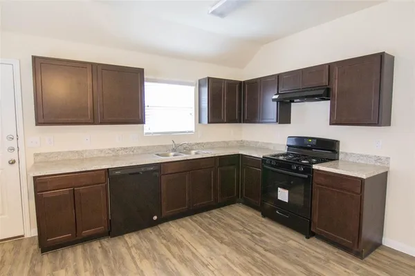 a kitchen with stainless steel appliances granite countertop a stove a sink and a microwave