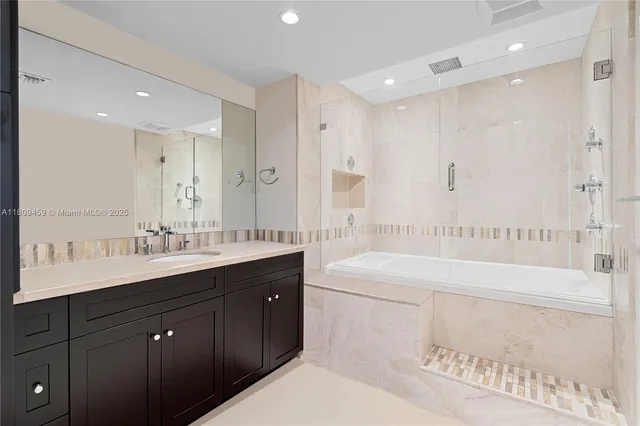 a bathroom with a bathtub shower sink double vanity and mirror