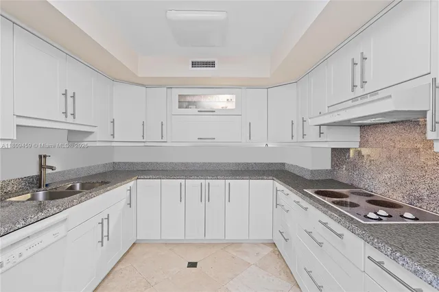 a kitchen with granite countertop white cabinets and appliances
