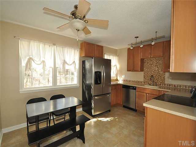 7804 Nugget Lane Raleigh, NC 27615 - Photo 5 of 10 a kitchen with a refrigerator a sink and cabinets