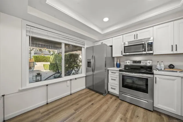 a kitchen with stainless steel appliances granite countertop a stove a microwave and a sink