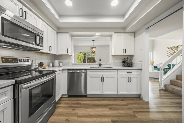 a kitchen with stainless steel appliances granite countertop a stove a sink and a microwave