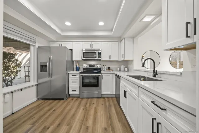 a kitchen with stainless steel appliances a refrigerator sink and cabinets