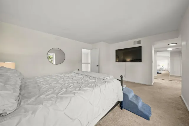 a bedroom with a bed and a flat screen tv