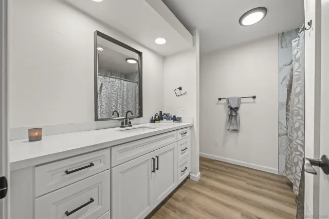 a spacious bathroom with a double vanity sink a mirror and shower