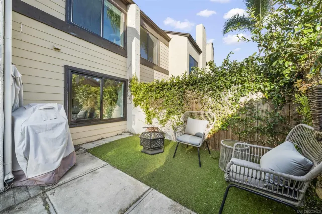 a view of a chair and table in backyard of the house