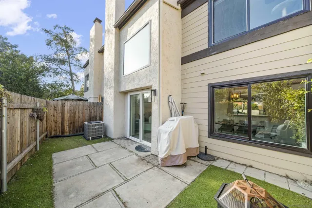 a view of a white house with a couches chair and grass