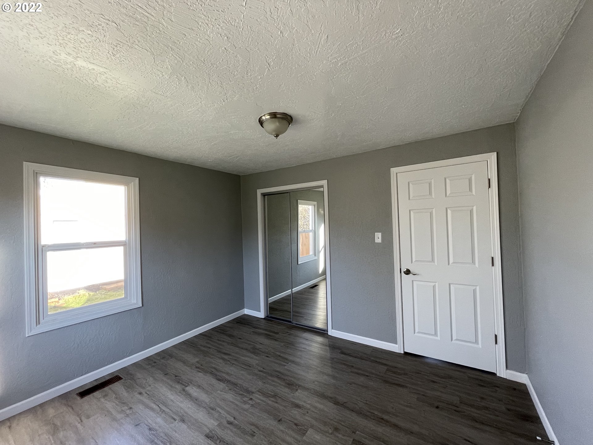 616 32nd Street Springfield, OR 97478 - Photo 23 of 28 a view of an empty room with wooden floor and a window