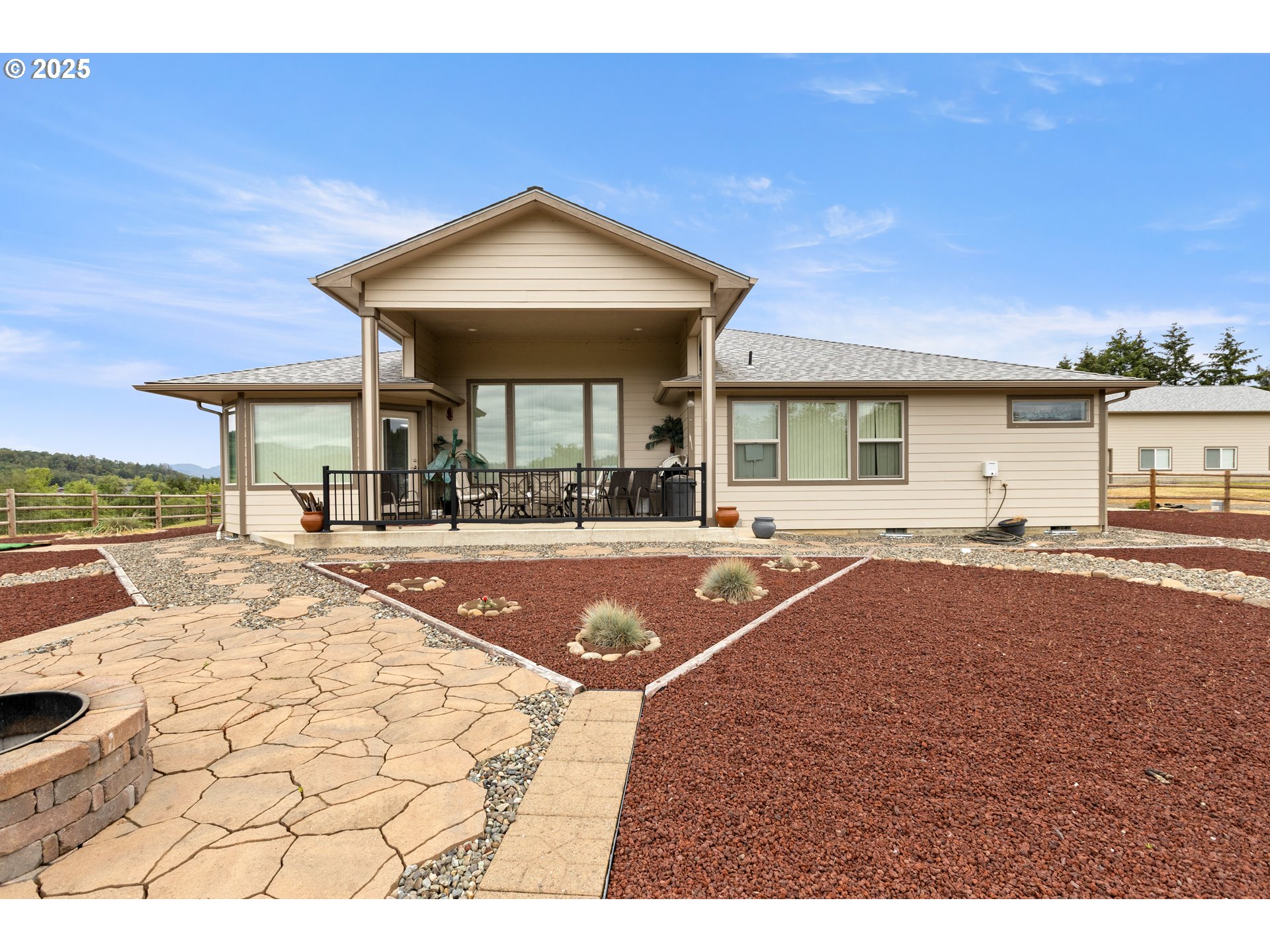 910 Swallow Avenue Sutherlin, OR 97479 - Photo 44 of 44 a view of a house with dining table and chairs under an umbrella