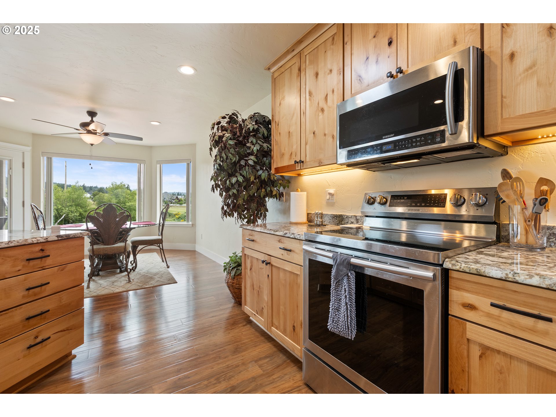 910 Swallow Avenue Sutherlin, OR 97479 - Photo 9 of 44 a kitchen with stainless steel appliances kitchen island granite countertop a stove top oven a sink with dining table and chairs