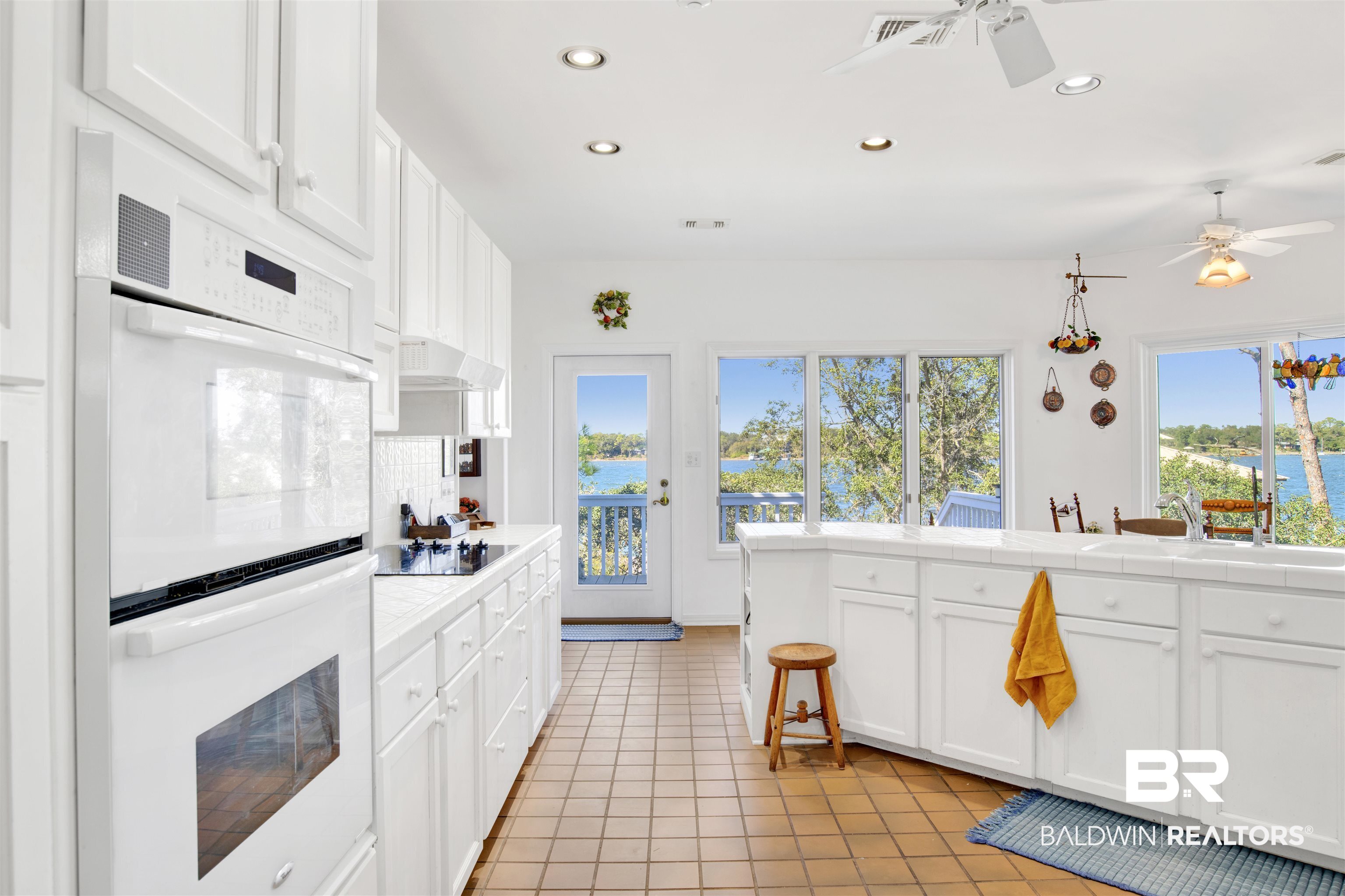 33301 River Road, Unit 25 Orange Beach, AL 36561 - Photo 4 of 44 Kitchen featuring tasteful backsplash, tile counters, a wealth of natural light, double oven, and black electric cooktop