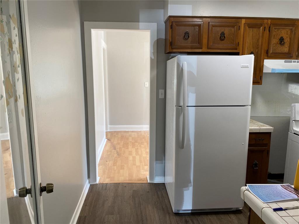 5441 18th Street Zephyrhills, FL 33542 - Photo 15 of 50 a white refrigerator freezer and a wooden floor