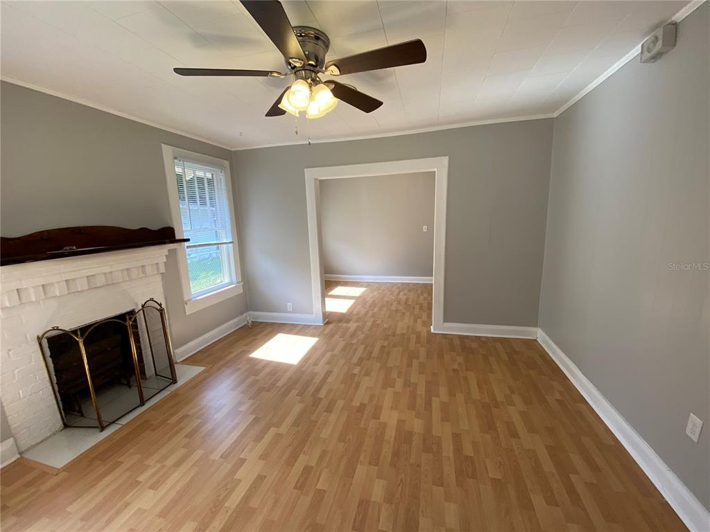 5441 18th Street Zephyrhills, FL 33542 - Photo 21 of 50 a view of an empty room with wooden floor fireplace and a window
