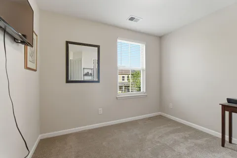 a bedroom with a bed tv and a window