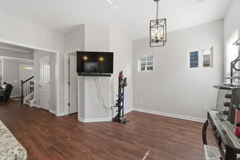 a view of a livingroom with wooden floor and a flat screen tv