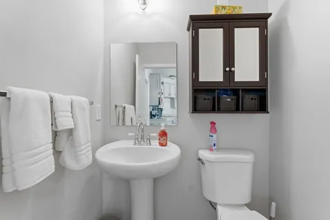 a bathroom with a sink toilet and mirror