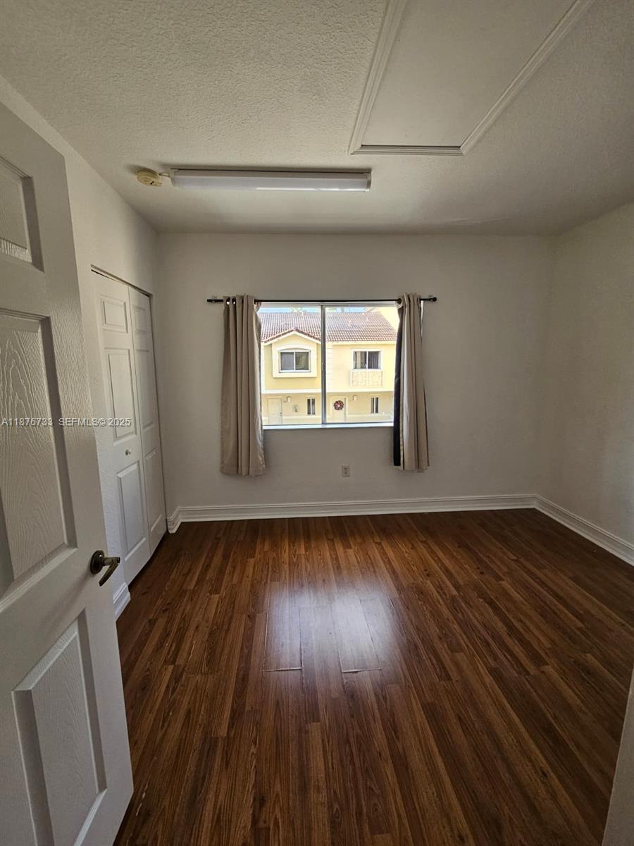 7995 Northwest 8th Street, Unit 103 Miami, FL 33126 - Photo 11 of 17 an empty room with wooden floor and windows