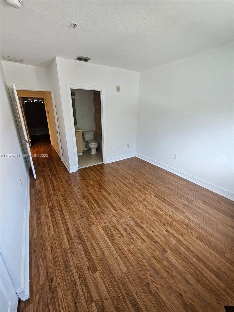 7995 Northwest 8th Street, Unit 103 Miami, FL 33126 - Photo 15 of 17 a view of a livingroom with wooden floor and staircase
