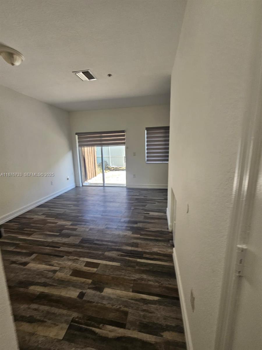 7995 Northwest 8th Street, Unit 103 Miami, FL 33126 - Photo 5 of 17 a view of an empty room with wooden floor and a window