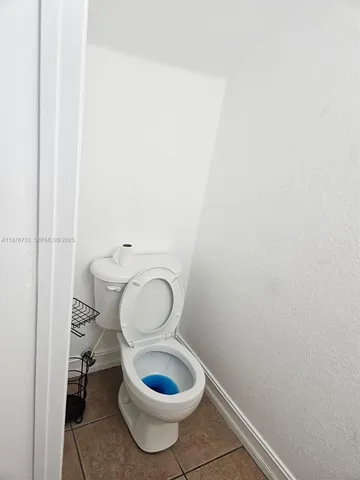 a white toilet sitting next to a white wall