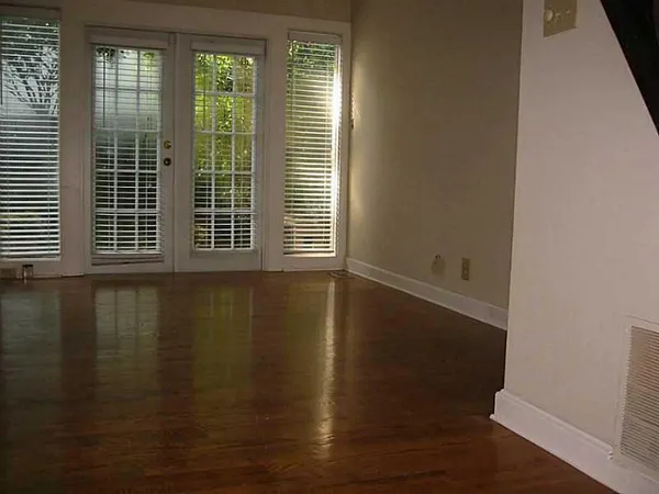 a view of empty room with wooden floor and windows