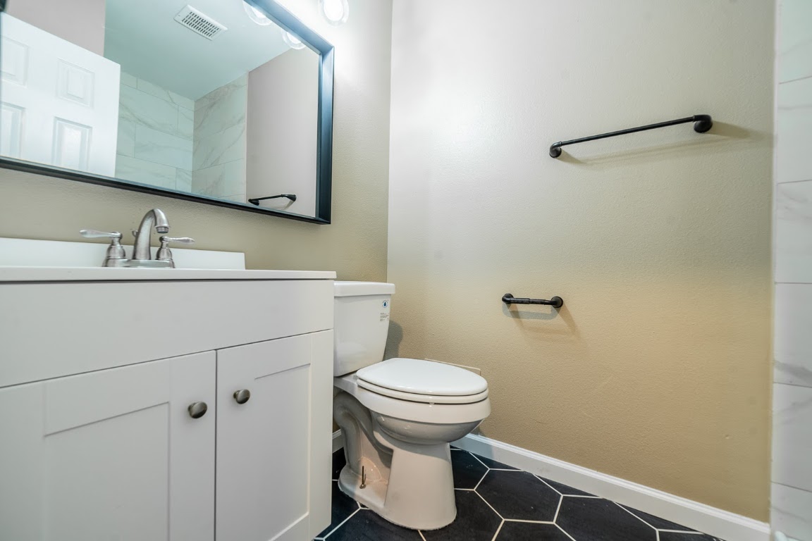 916 Sirocco Drive, Unit B Austin, TX 78745 - Photo 10 of 18 a bathroom with a sink a toilet and a mirror