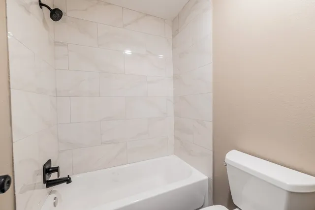 a bathroom with a granite countertop sink a toilet and shower