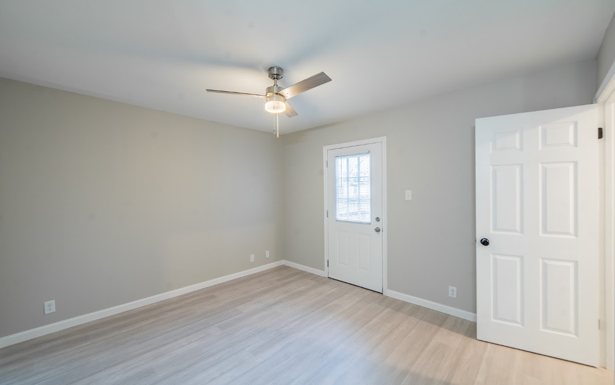 916 Sirocco Drive, Unit B Austin, TX 78745 - Photo 13 of 18 an empty room with wooden floor ceiling fan and windows