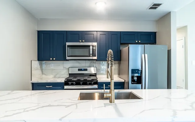 a kitchen with granite countertop a refrigerator and a sink