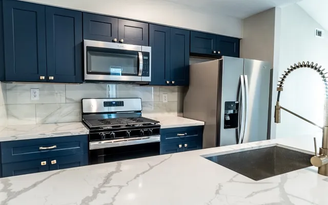 a kitchen with granite countertop wooden cabinets and stainless steel appliances